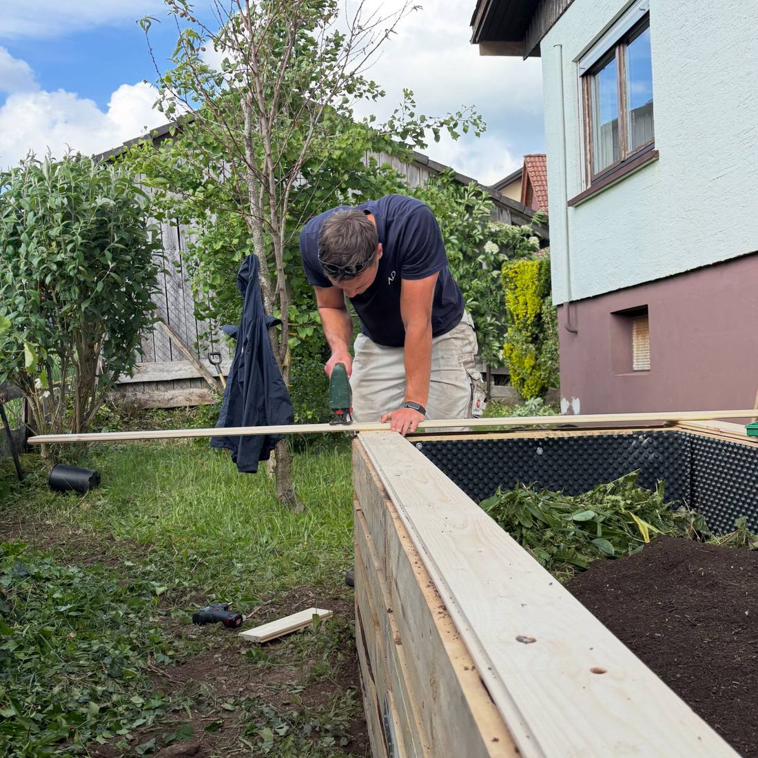 Selbstgebautes Hochbeet aus Holz im Garten